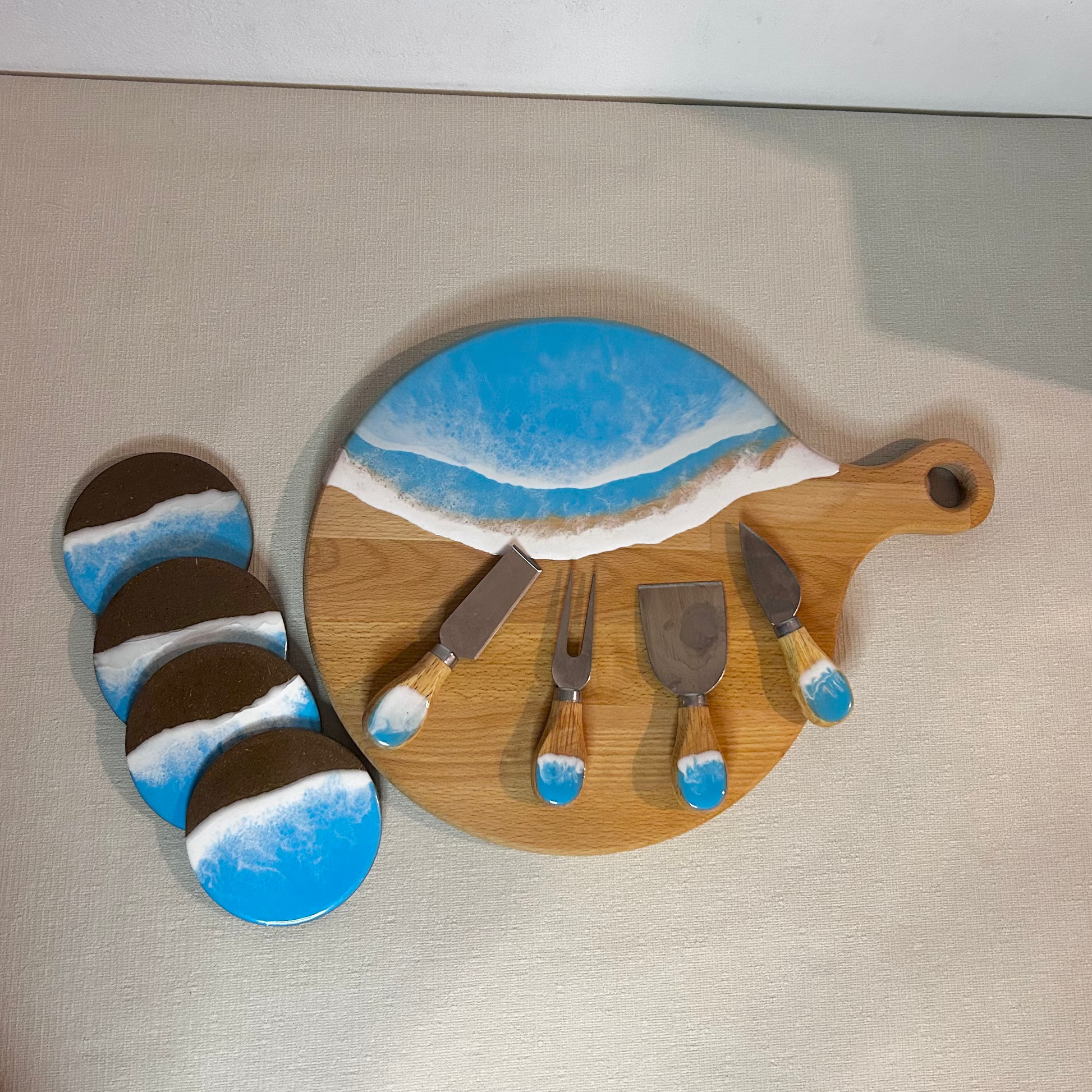 Set platou rotund cu maner, suporturi de pahare si cutite pentru branzeturi cu rasina epoxidica, efect ocean albastru deschis. Personalizata cu un mesaj ales de tine - epoxyarta.ro