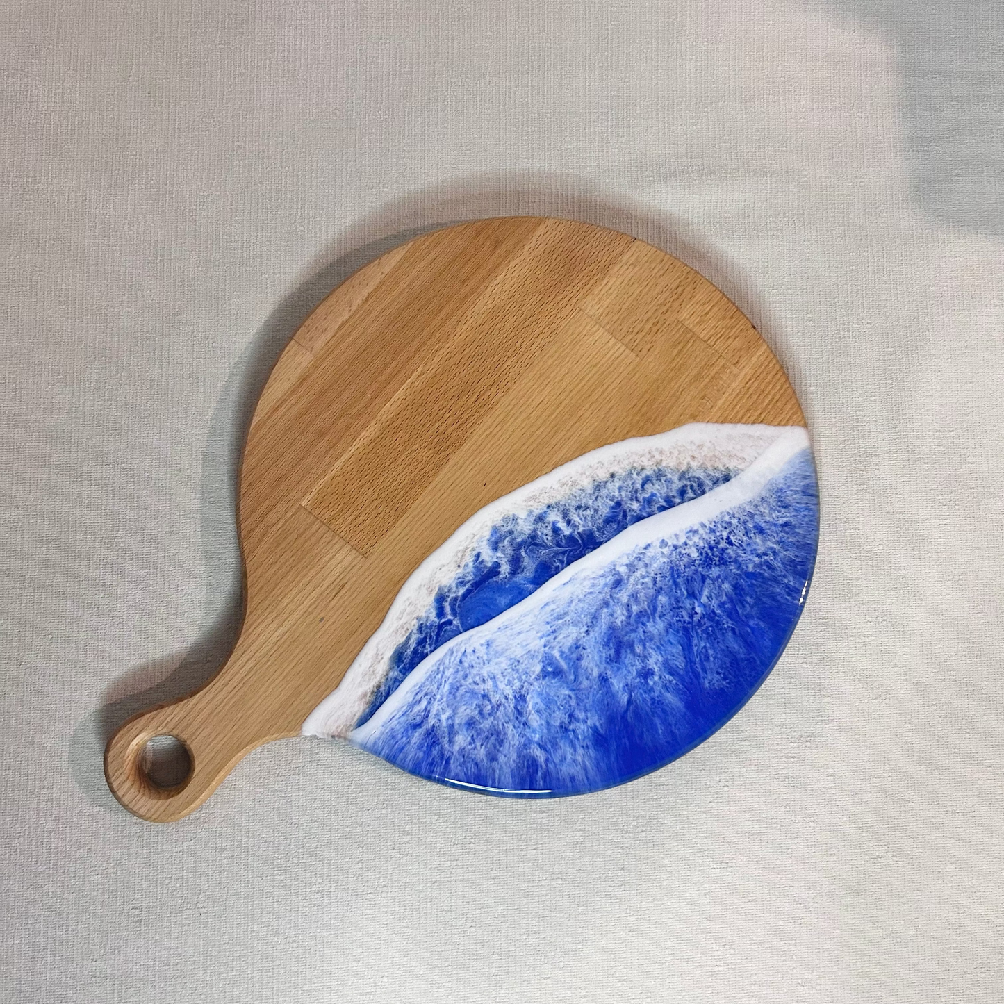 Platou / tocator rotund cu maner din lemn de fag cu rasina epoxidica, efect ocean albastru. Personalizata cu un mesaj ales de tine - epoxyarta.ro
