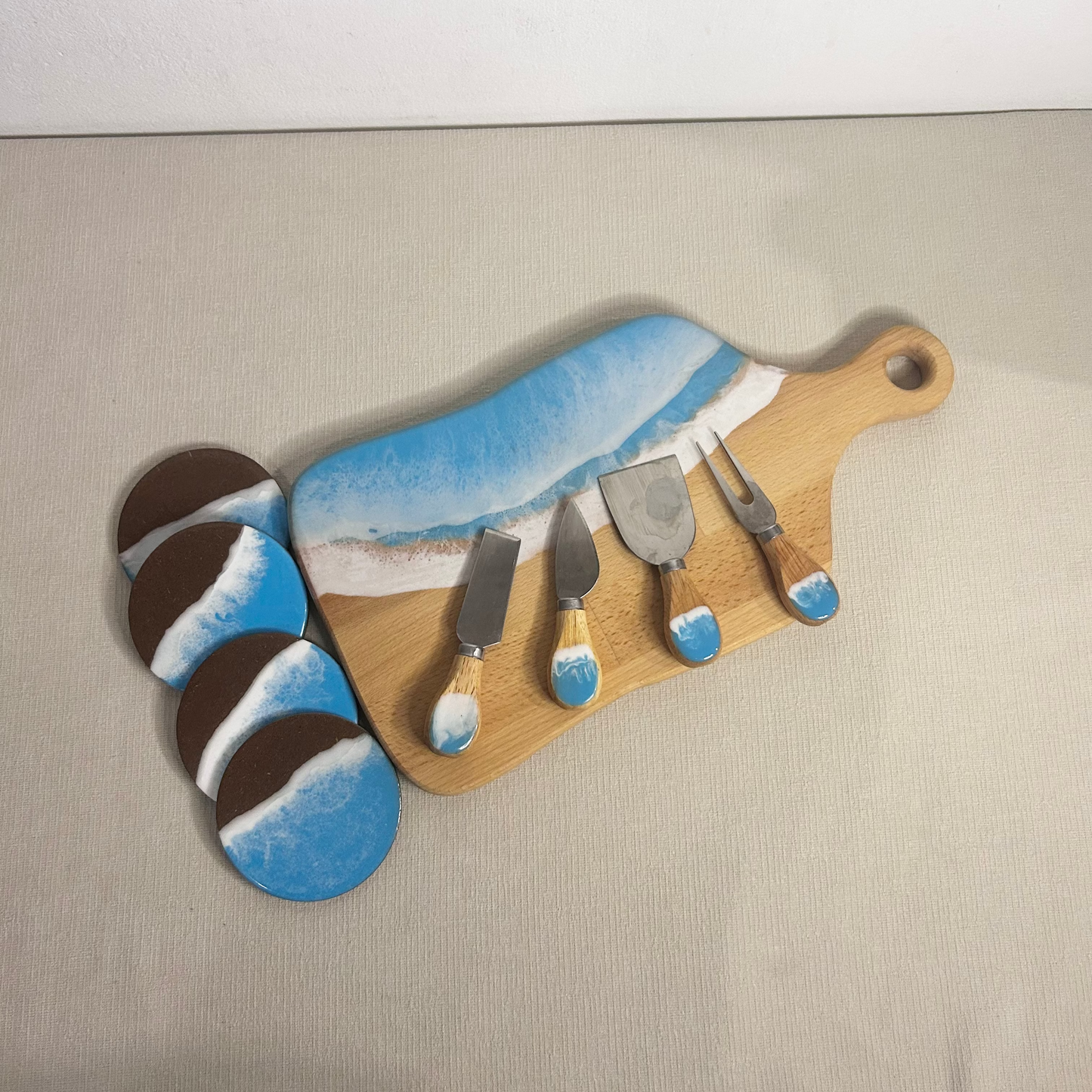 Set platou dreptunghiular cu maner, suporturi de pahare si cutite pentru branzeturi cu rasina epoxidica, efect ocean albastru deschis. Personalizata cu un mesaj ales de tine - epoxyarta.ro