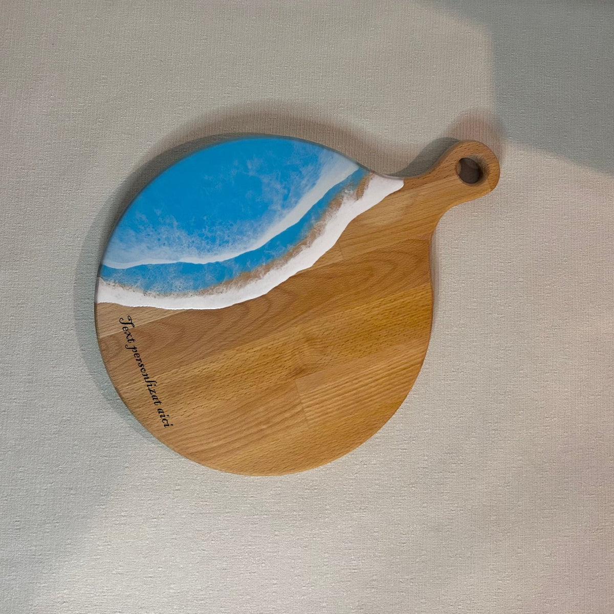 Platou / tocator rotund cu maner din lemn de fag cu rasina epoxidica, efect ocean albastru deschis. Personalizata cu un mesaj ales de tine - epoxyarta.ro